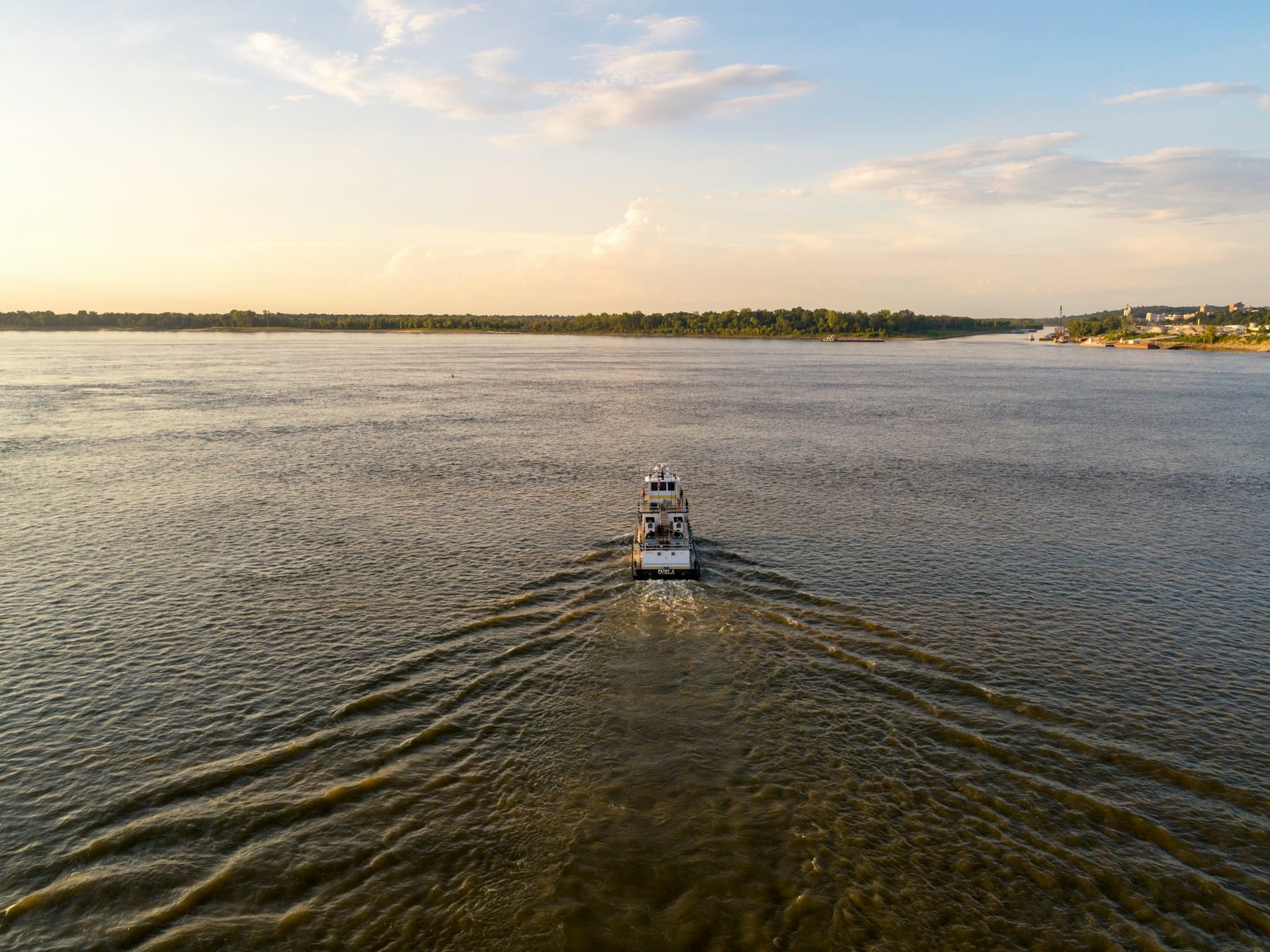 a tugboat moves down a river