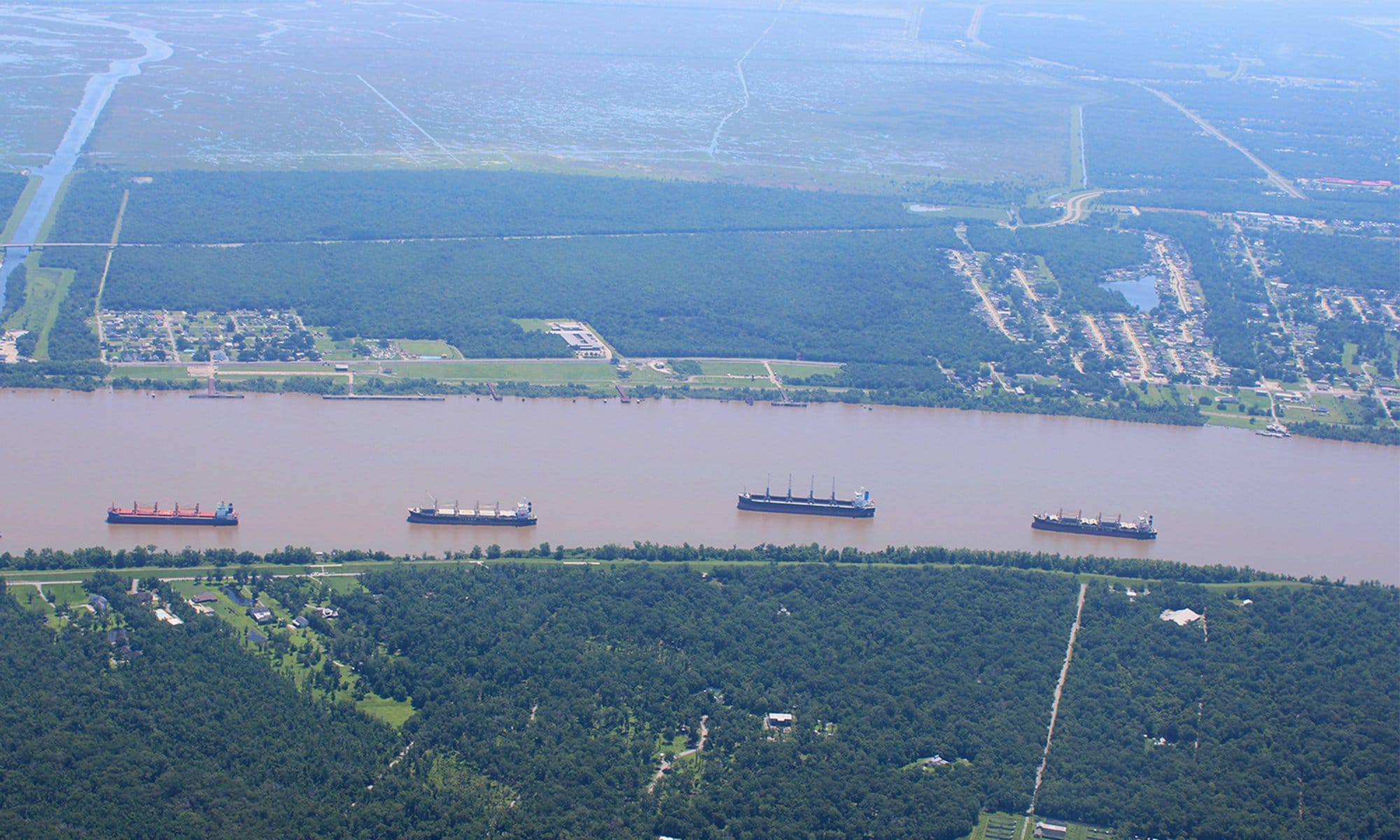 Caption: Freight ships make their way north along the lower Mississippi River in Plaquemines Parish, Louisiana.