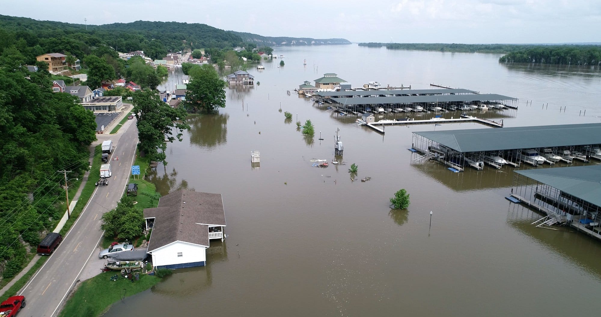 Aerial view of a town's riverfront with structures poking out from the water