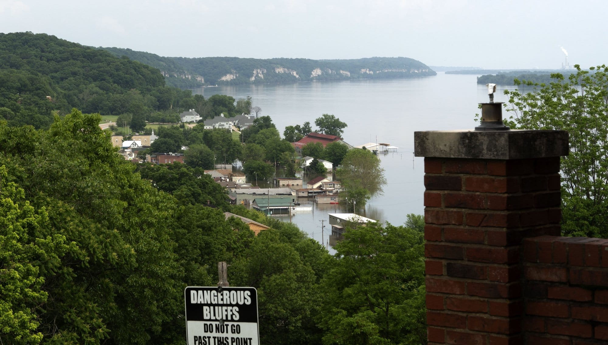 A town next to a large body of water is seen flooded below.