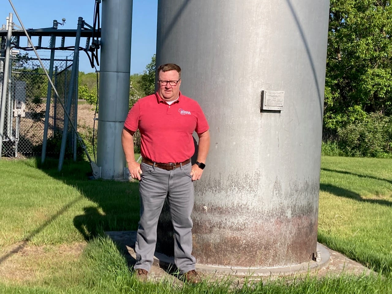 A man stands outside by electrical infrastructure