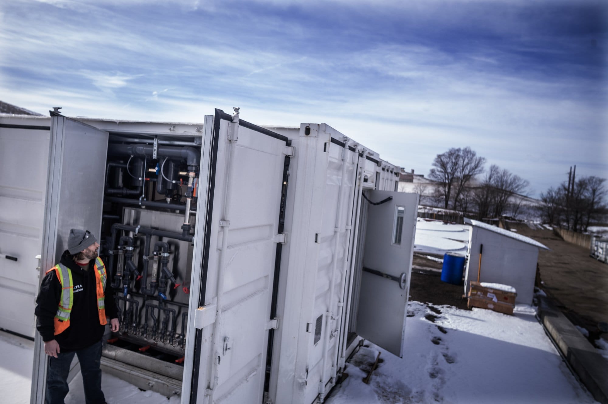 Project manager James Locurto stands beside a containerized filtration system used to remove PFAS from landfill leachate in Rosemount, Minnesota.