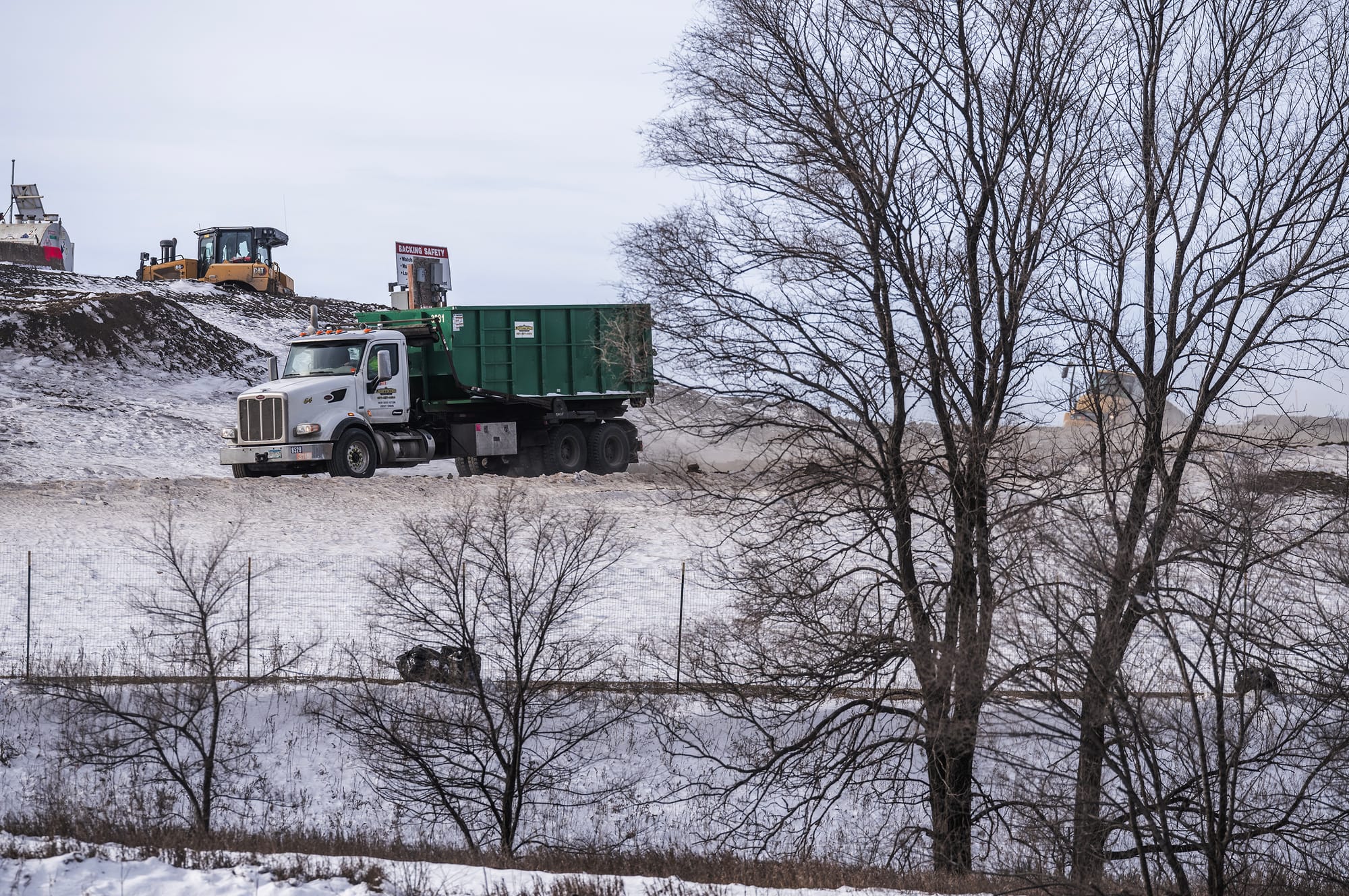 A dump truck drives through a waste site
