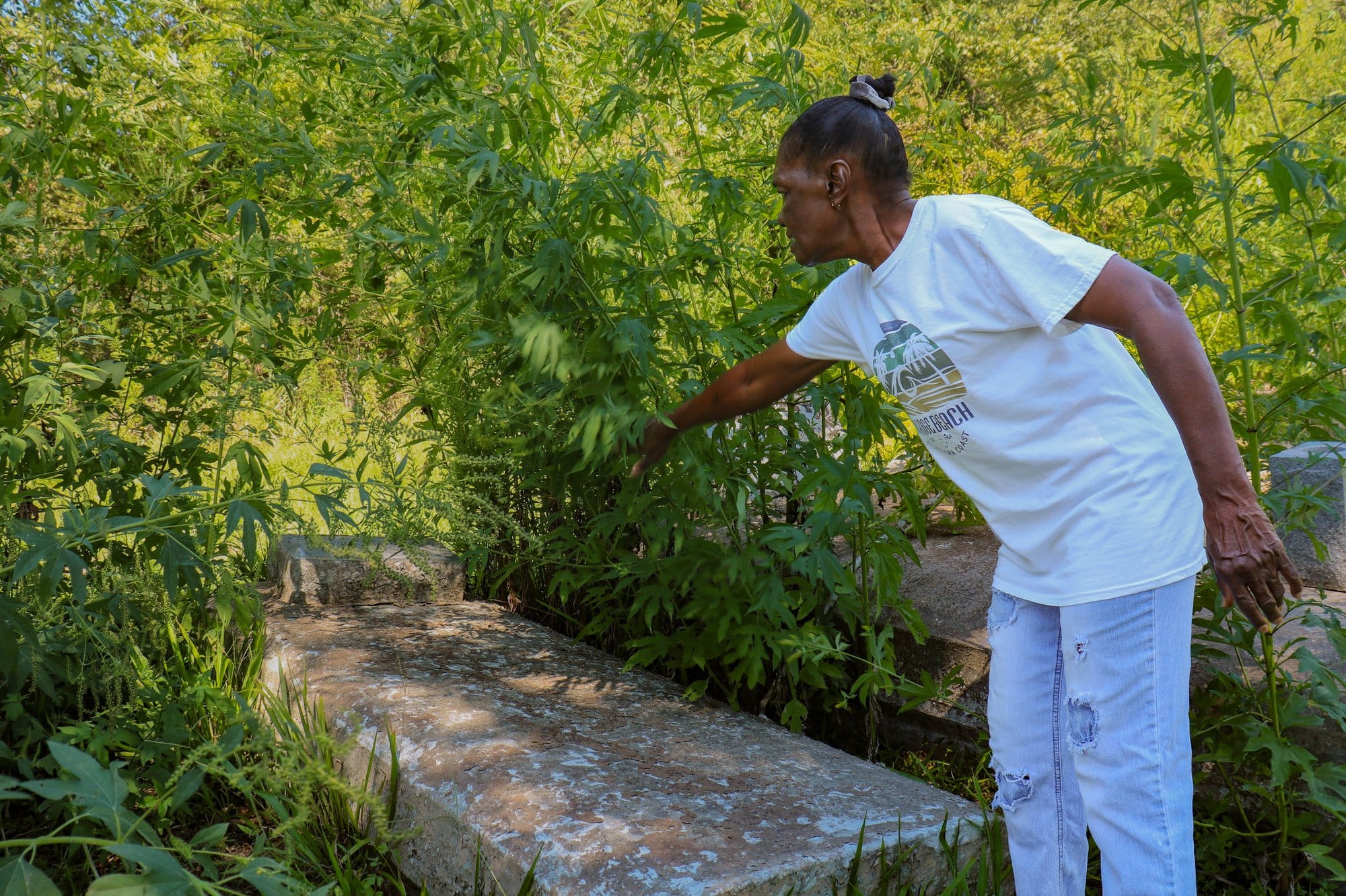 Wallace resident Isabella Poche stands beside her mother’s above-ground tomb in Willow Grove Cemetery, next to her home.