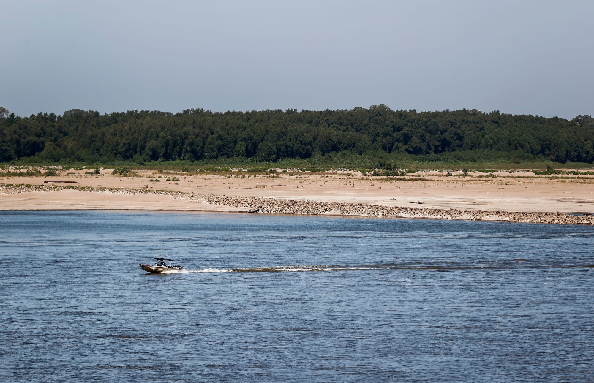 A boat passes through low waters on the river