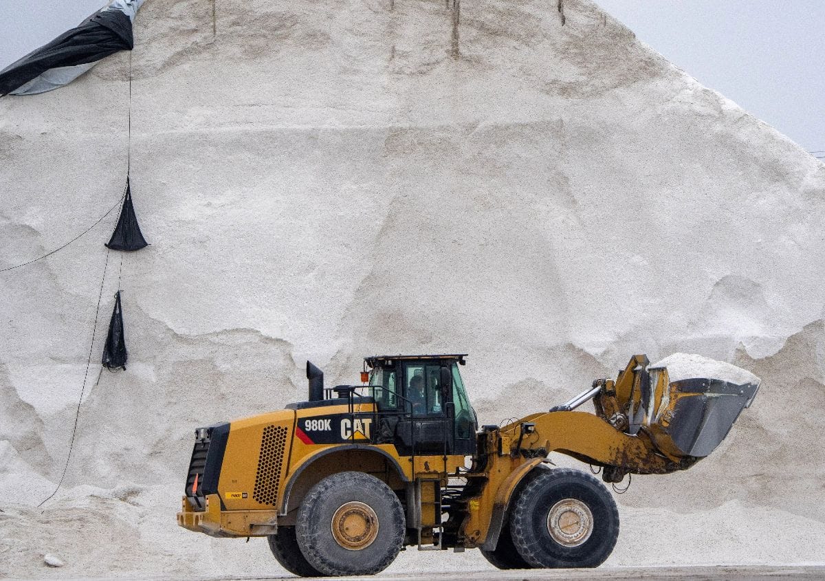 A loader tractor moves road salts