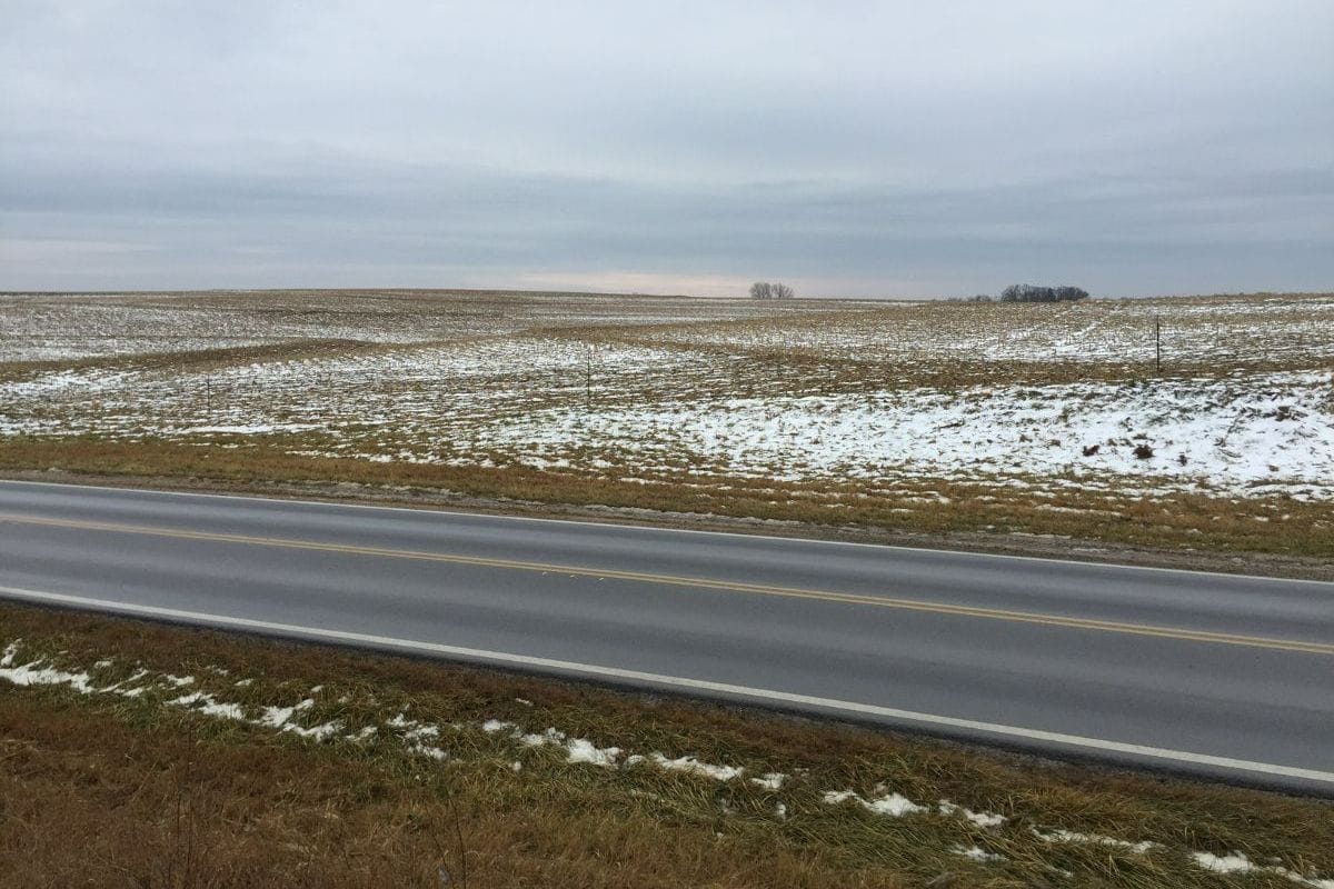 Snow covered fields by a highway
