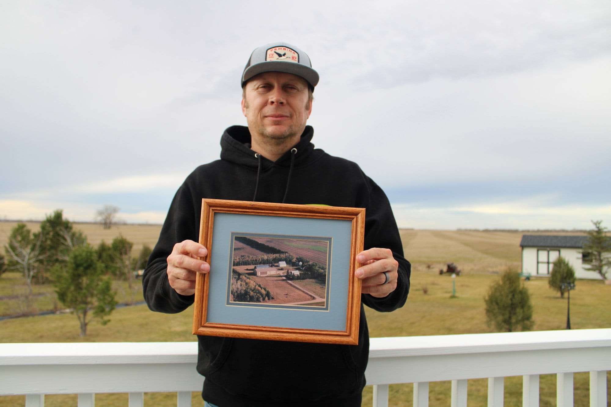 Stafslien holding a picture of his farm.