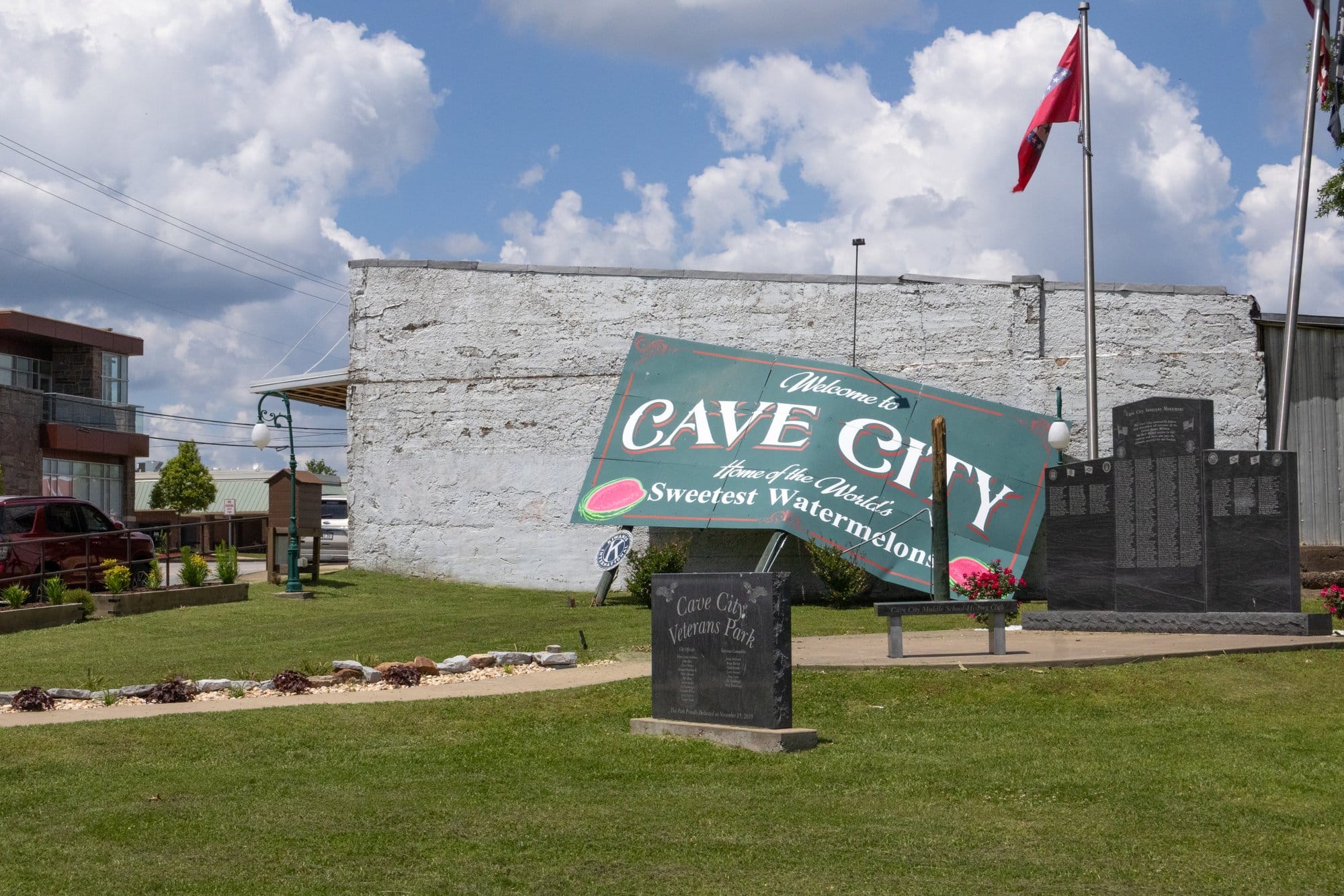 Cave City’s welcome sign rests against a building.