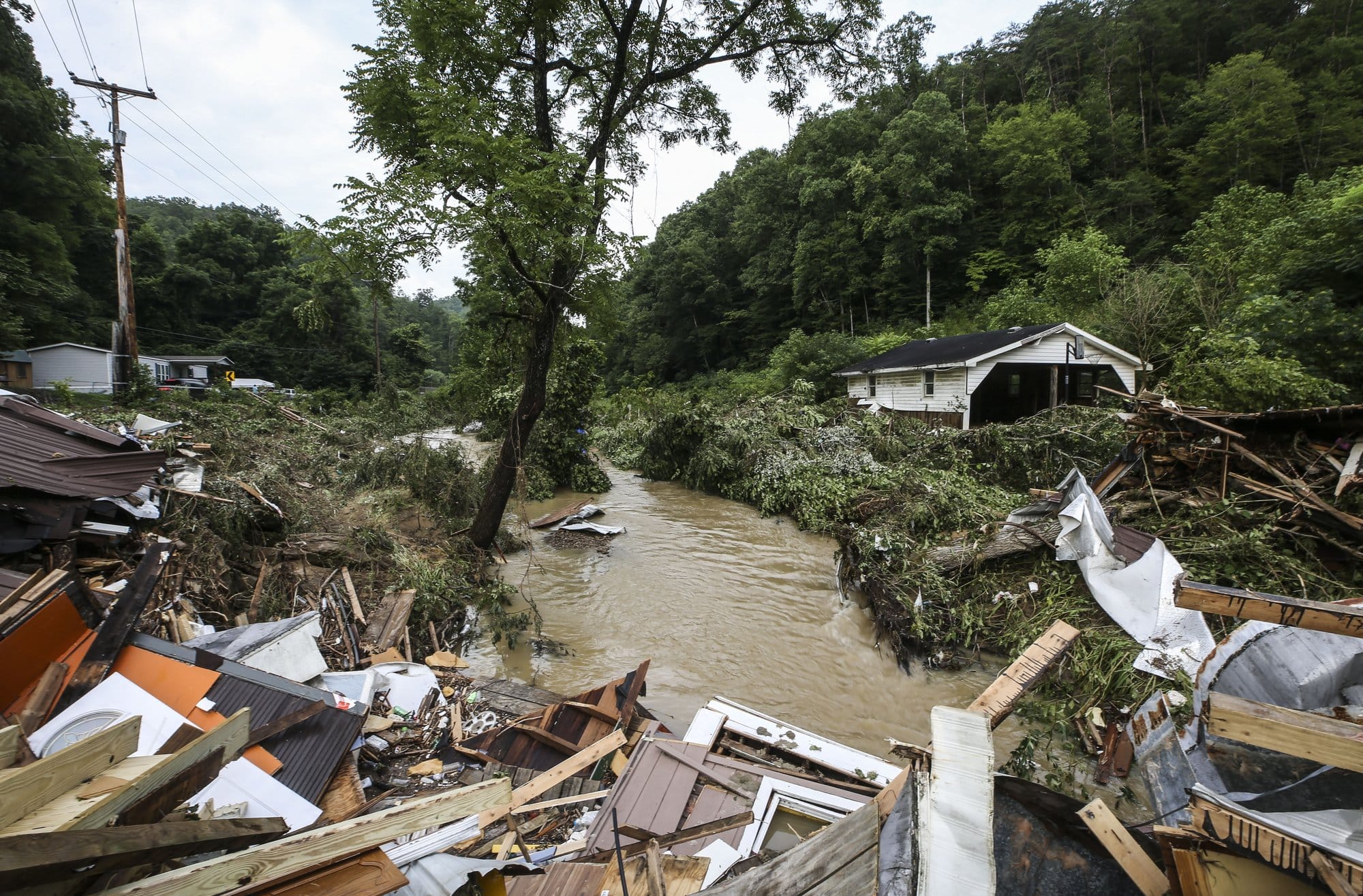 Debris from destroyed homes piles up near a concrete bridge
