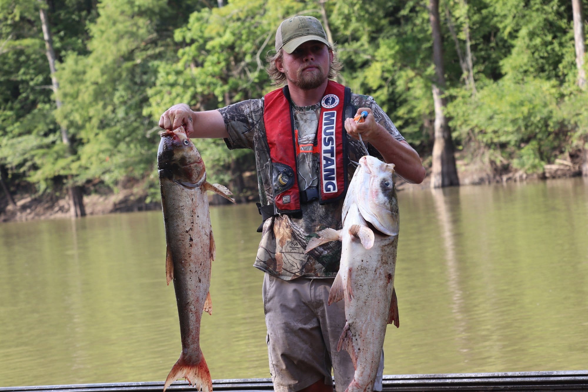 Chism holds up two species of Invasive Carp.