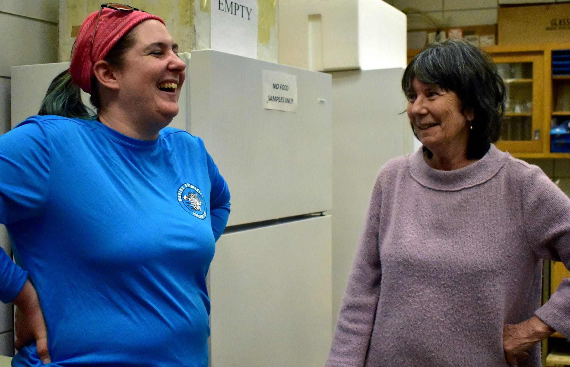 Two women share a laugh in a lab.
