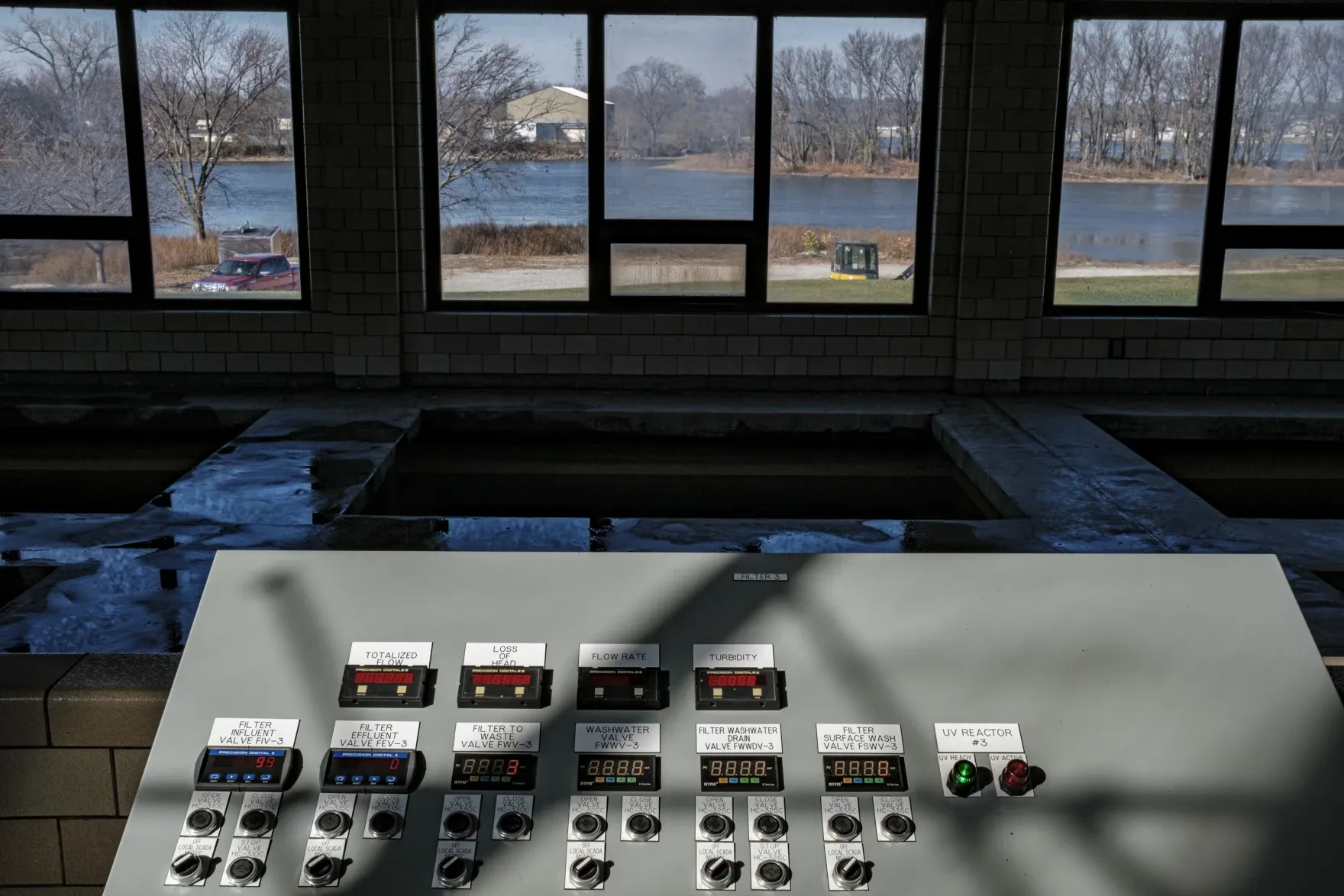 Control panels and filtration basins inside the Moline Water Treatment Plant, with the Mississippi River visible through the windows.