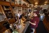 Owner Mike Adank, left, helps a customer buying souvenirs at Thursday, May 28, 2026 at The Corner Store in Fountain City,