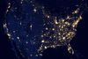 A satellite image of the continental United States at night shows light in city centers.