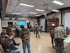 Hunters in camo mill about in a room full of taxidermy