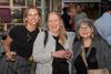 three women smile at an event 
