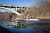 A team of 9 rowers paddle down a river in one long row boat