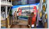 Artist's rendering of two tourists observing an installation of Helena-West Helena with a picture of a historic riverboat in the center
