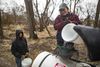 A worker loads water into a vessel while another person stands by with another bucket