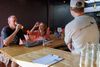 A man and woman drink glasses of Kernza beer at a table at a restaurant during release event at a St.Louis brewery.