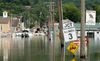 A crew works on the shore of a town that is flooded