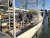 A man stands on the deck of a docked fishing boat