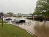 Cars sit in a flooded lot near apartment complexes