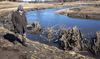 Tracy Hames walk past repurposed trees used to mitigate the flow of water along Black Earth Creek in in Mazomanie, Wisconsin.