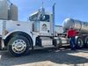 A man in a red shirt poses with a white semi-truck with an "ottawa coop" logo on the door