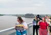 Advocates with loudspeaker and posters in-hand march over the Centennial Bridge.