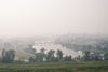 Fog settles over a town. There is a bridge across the water