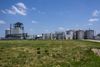 An industrial plant stands in a green field on a sunny day