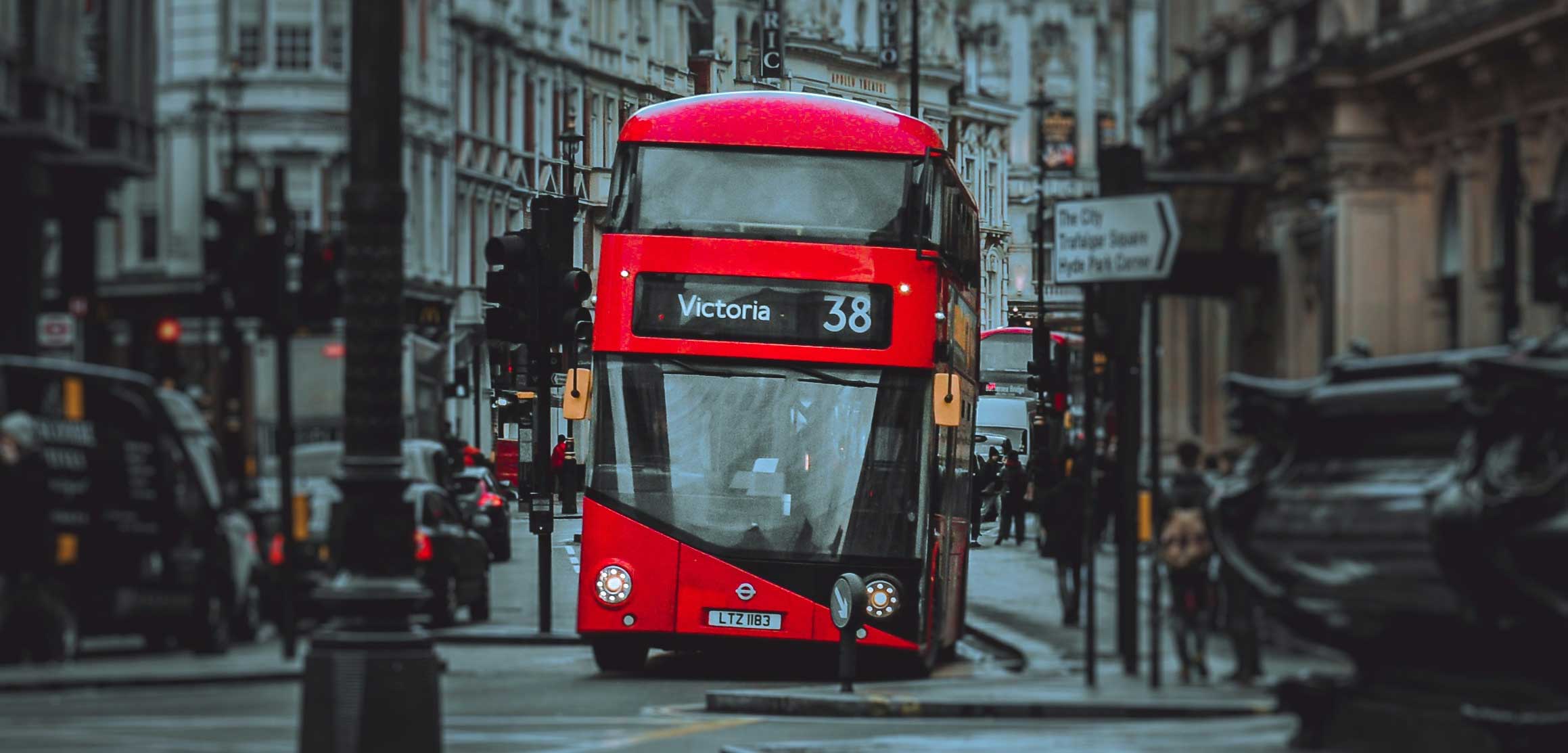 Double decker London city bus driving on roadway.