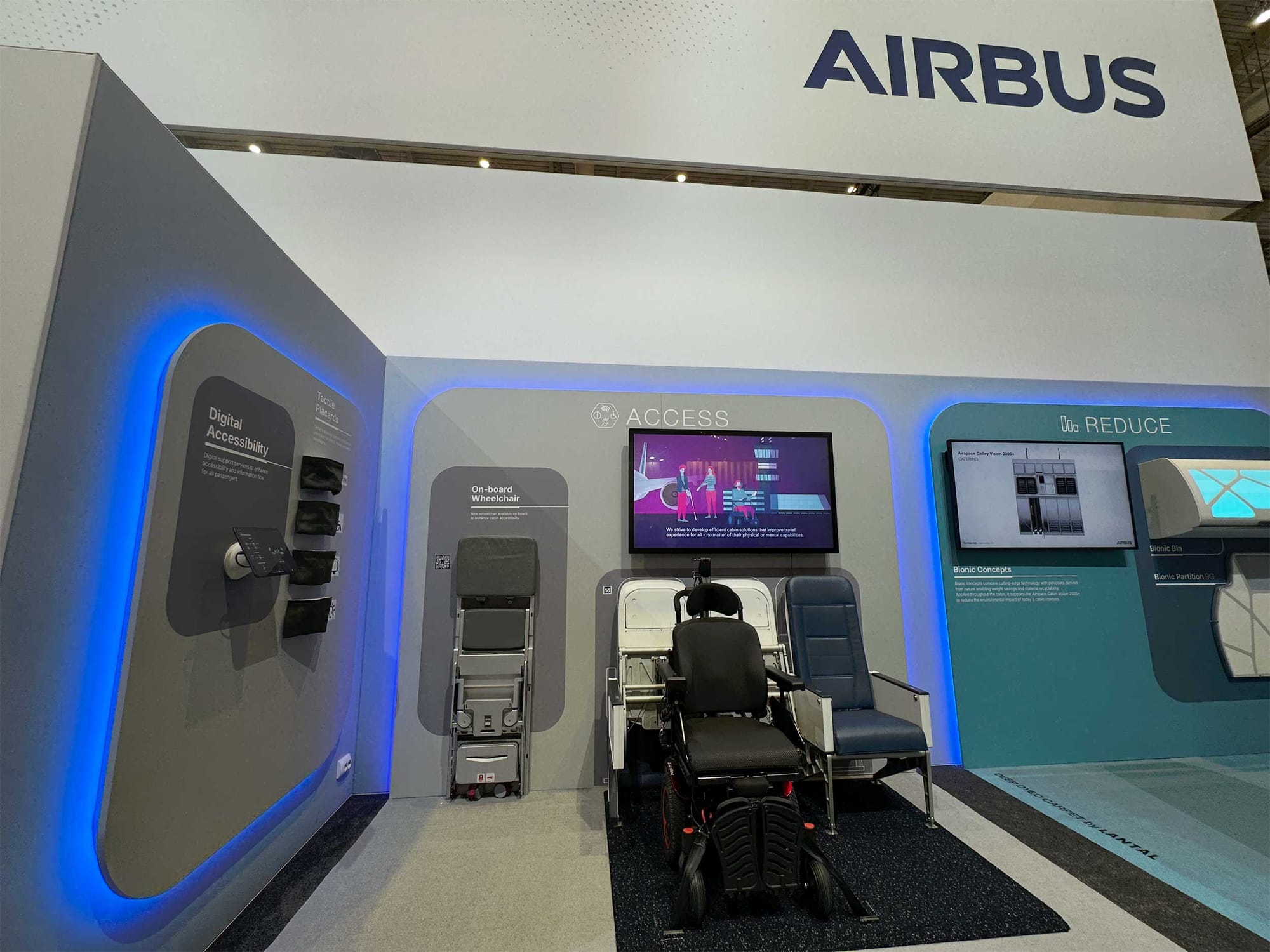 Wheelchair securement space, aisle chair and digital accessibility features displayed at an accessibility exhibit on the Airbus stand.