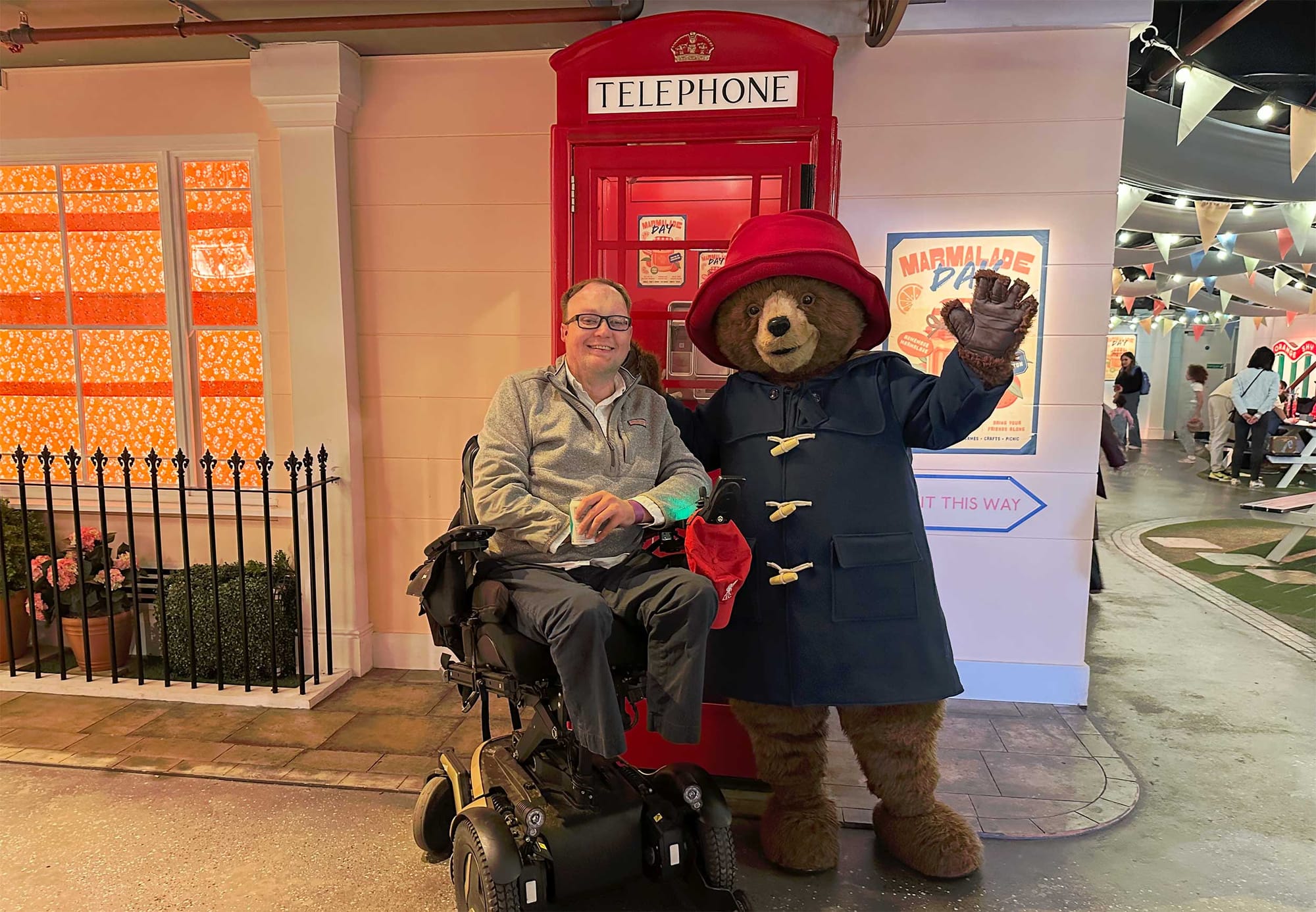 John pictured next to a person wearing a Paddington Bear costume.