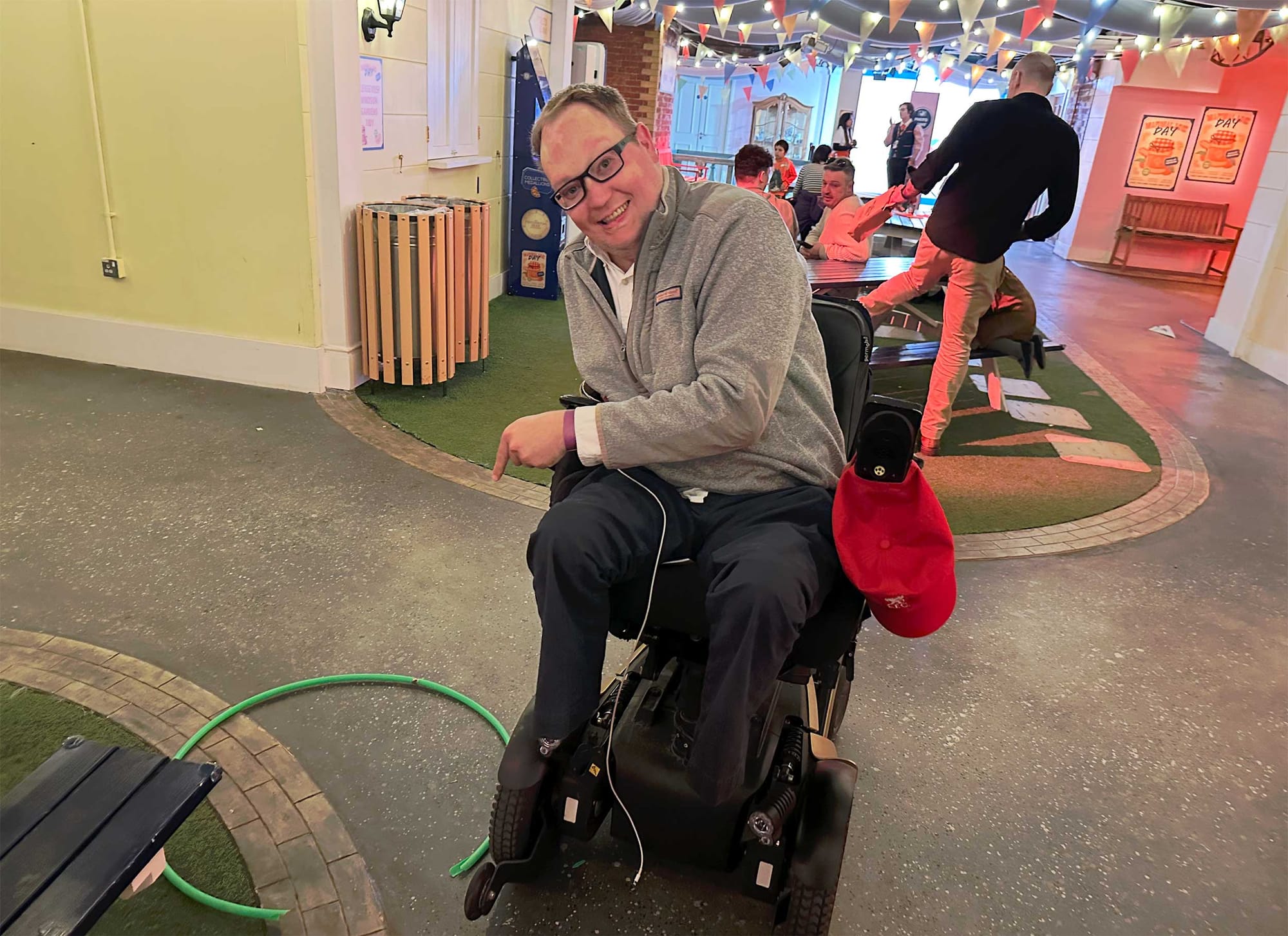 John seated in his wheelchair next to a broken hula hoop.