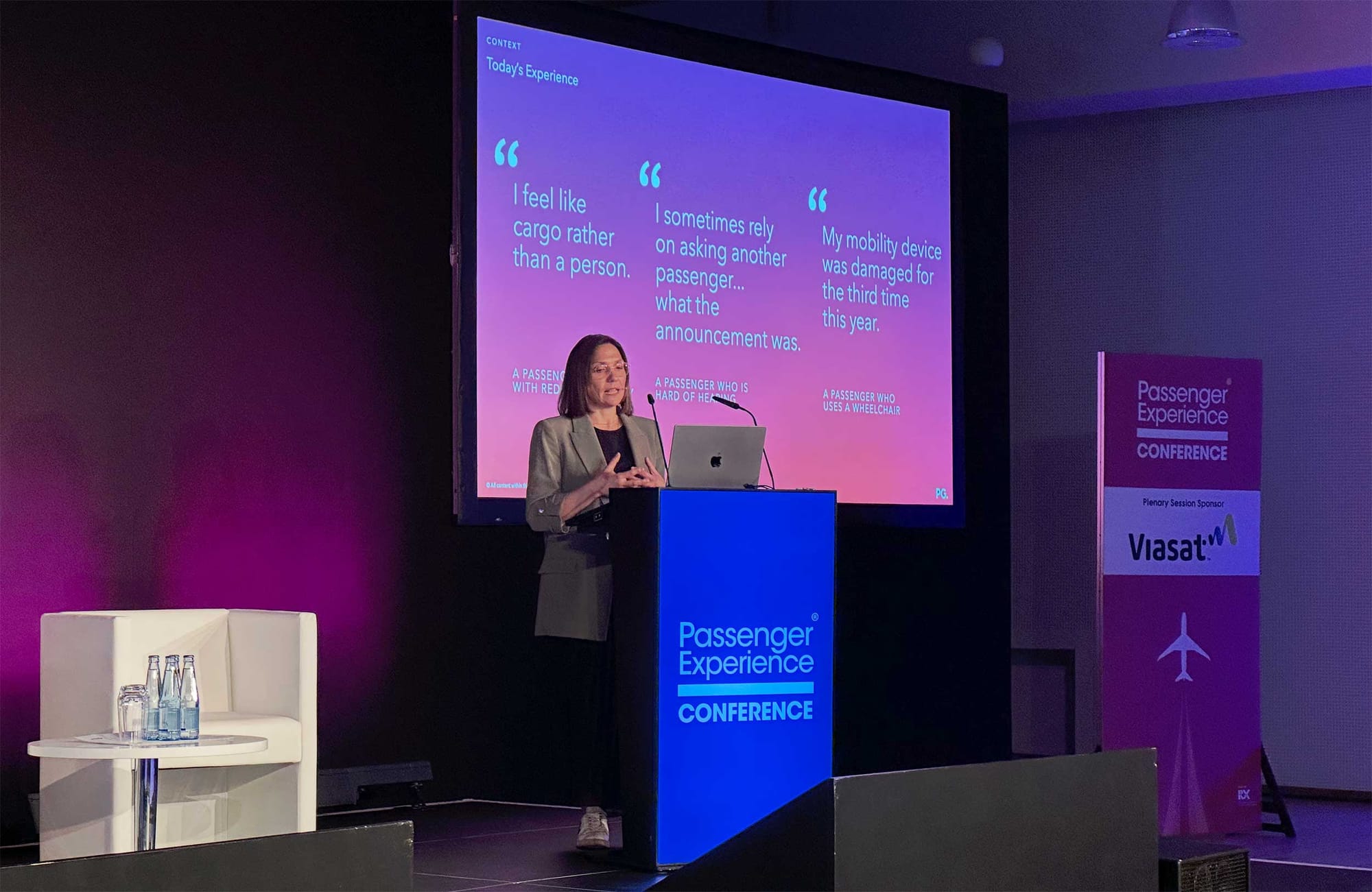 Jo Rowan standing behind the Passenger Experience Conference podium delivering a keynote address.