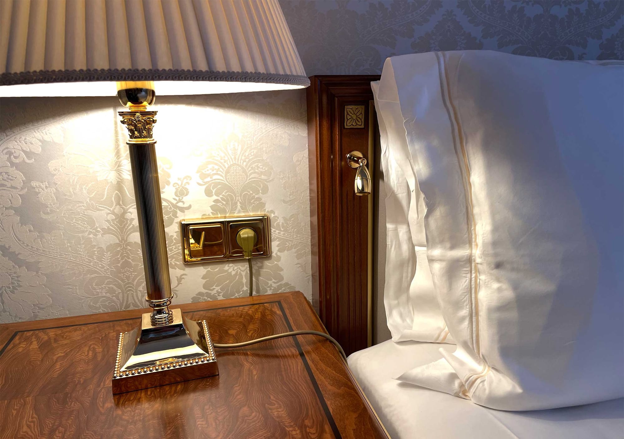 Lamp and power outlet next to bed.