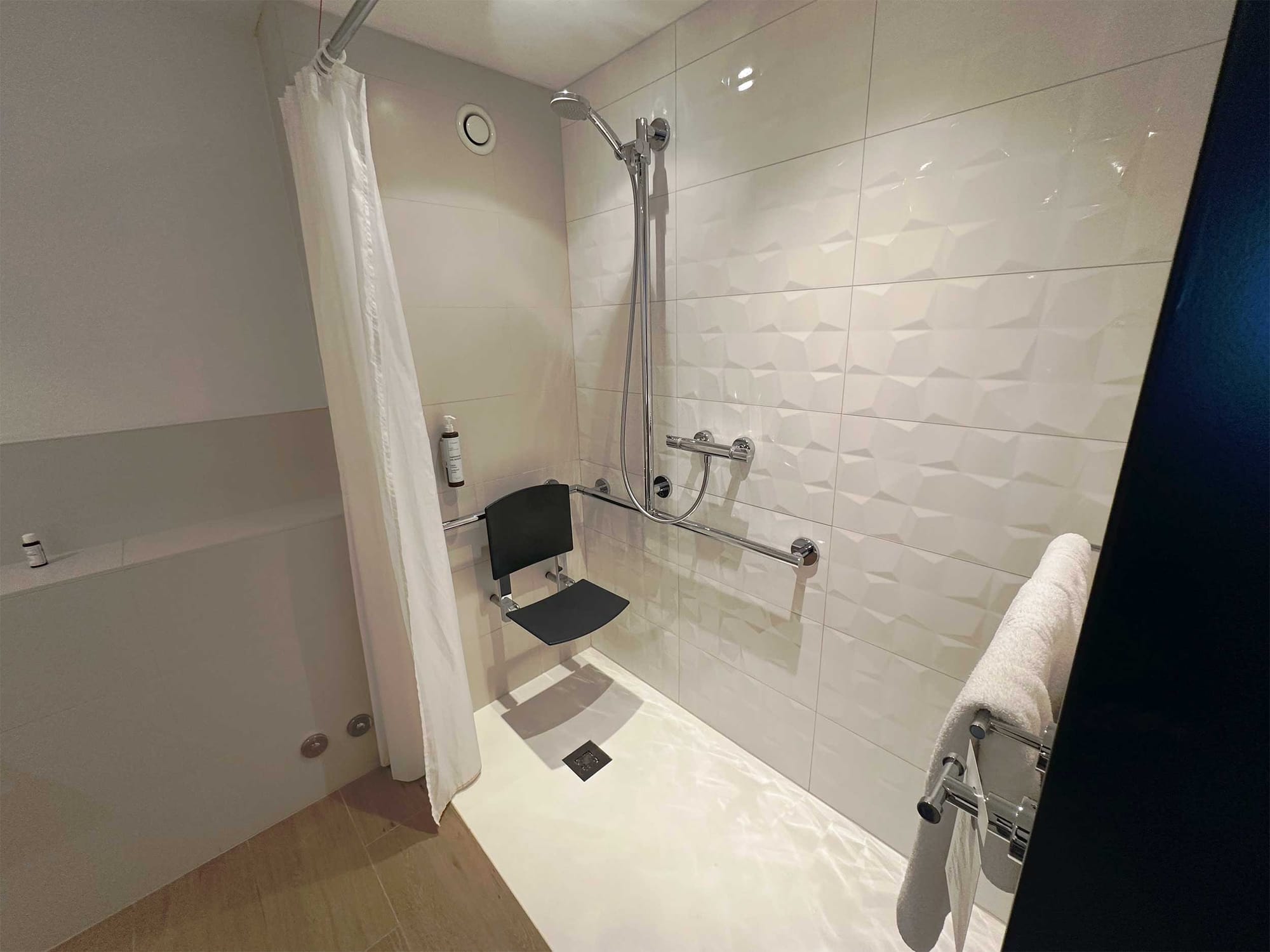 Roll-in shower with seat and grab bars.