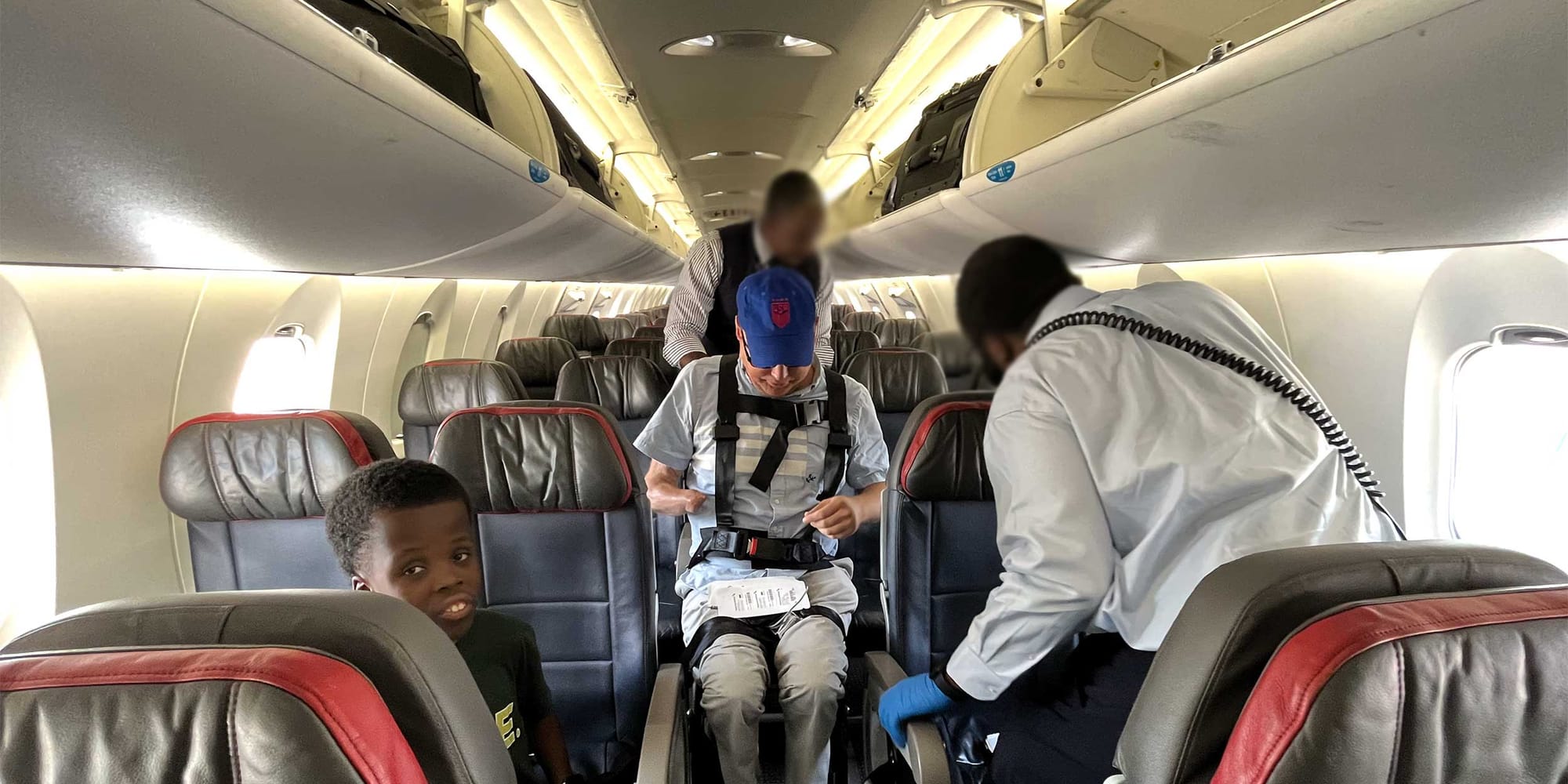 John deplaning a small regional jet in an aisle chair.