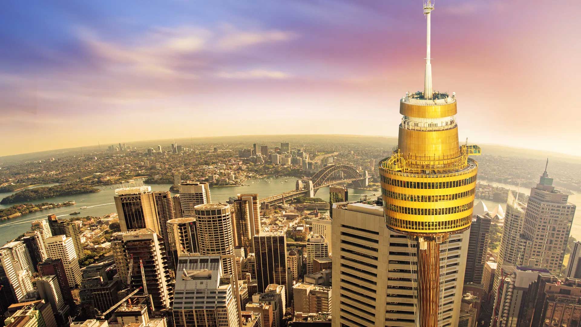 Tall observation tower over Sydney skyline.