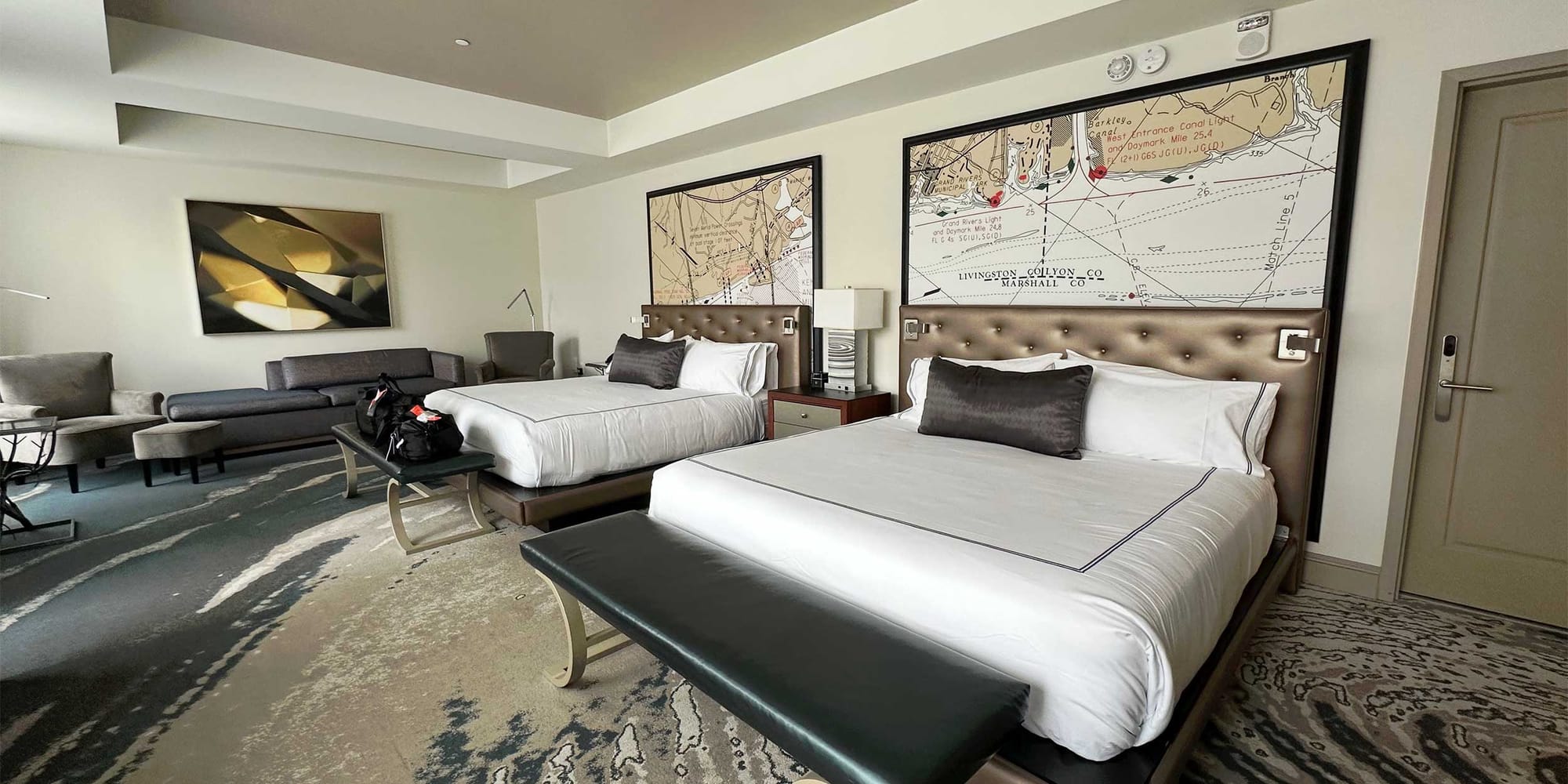 Hotel room with two king beds, beautiful carpet and artwork.