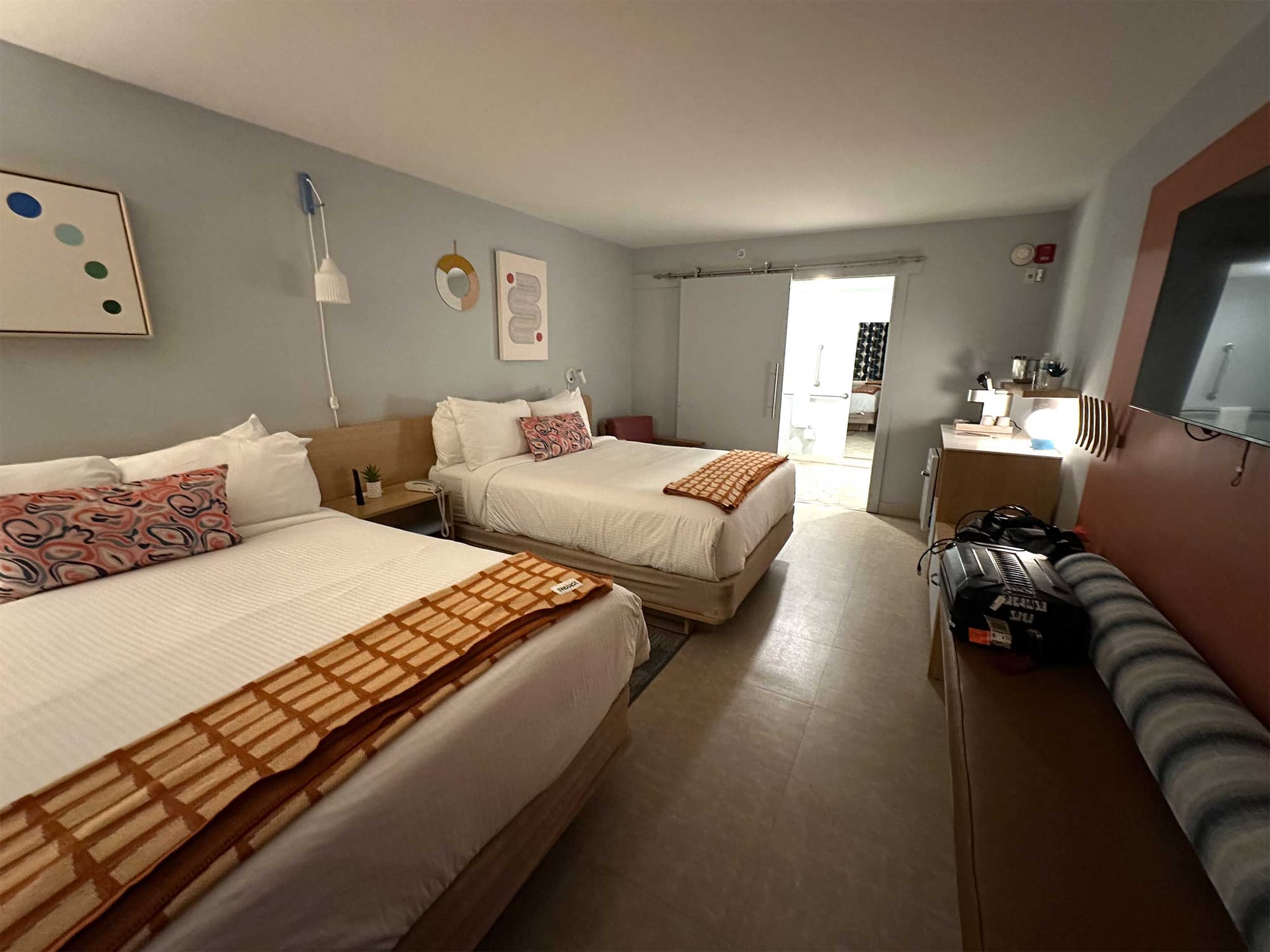 Two queen beds across from a wall-mounted television.