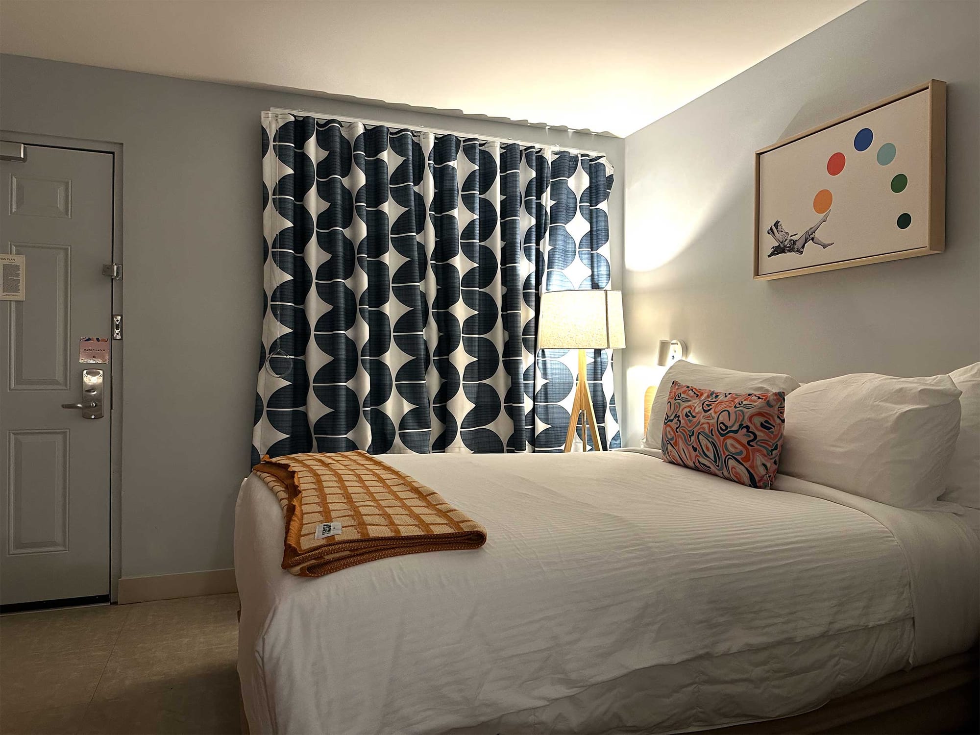 Hotel room entry door next to bed.