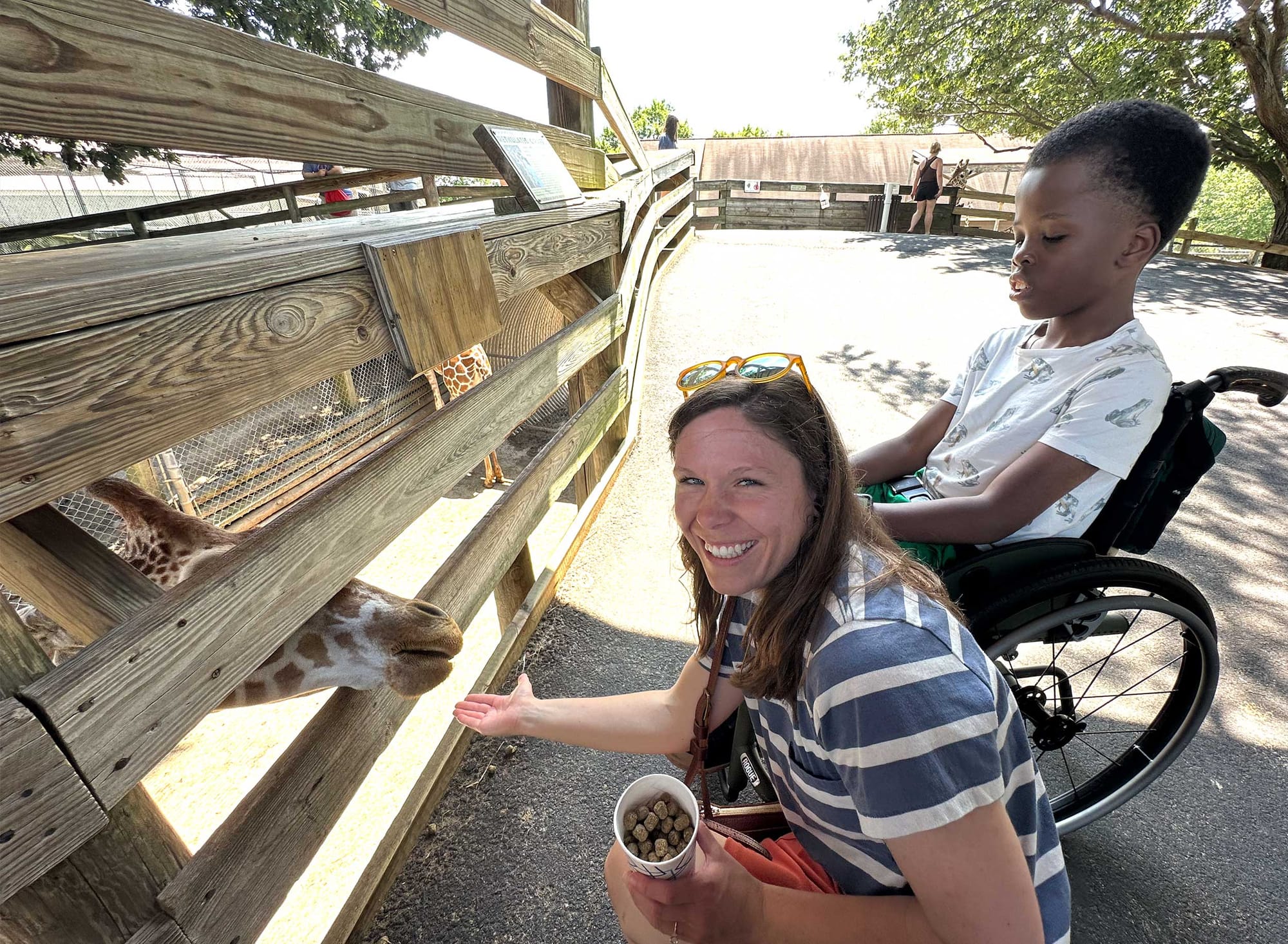 Stevie and Robert feeding a giraffe.