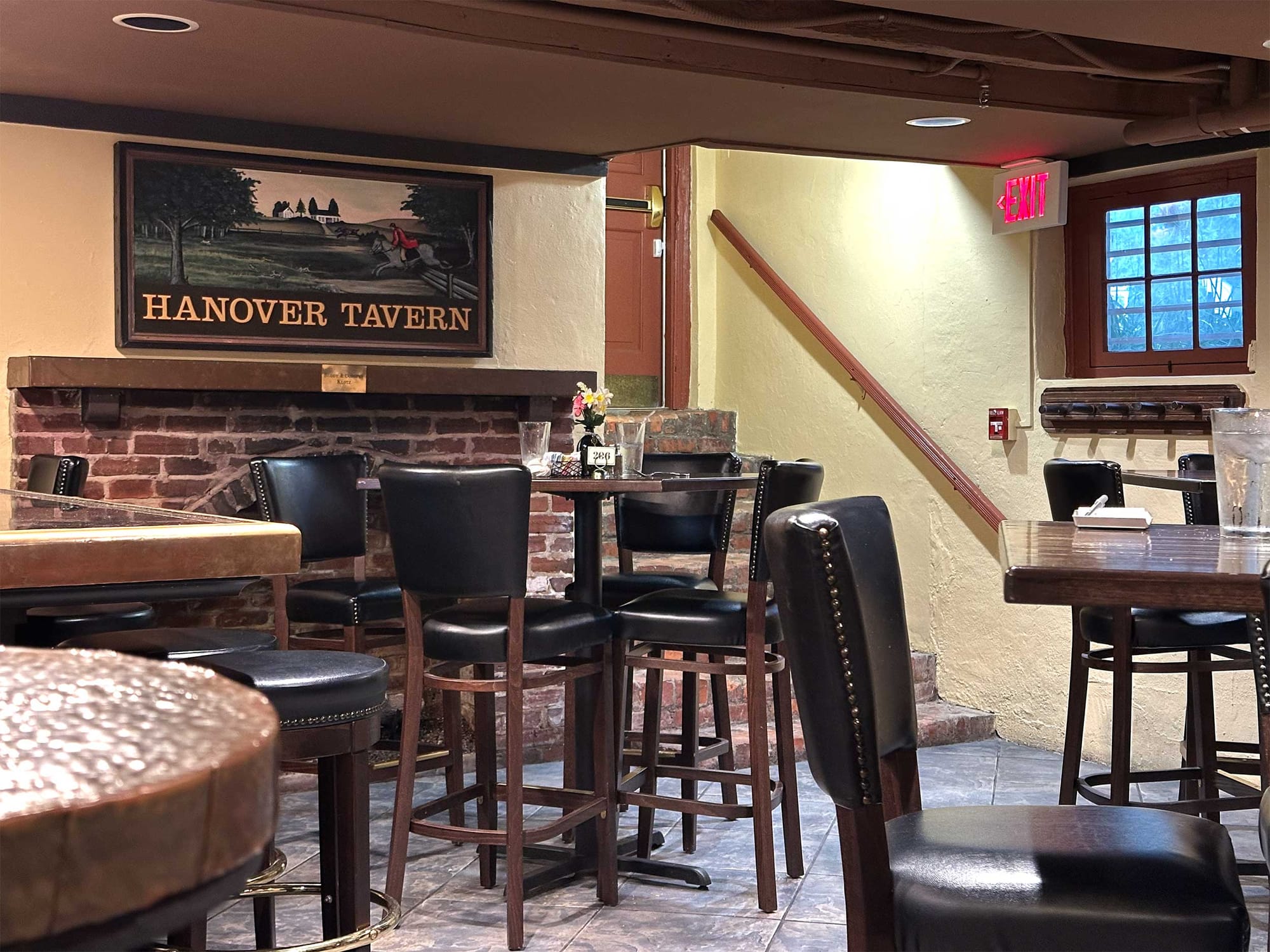 Hanover Tavern sign over fireplace in bar area.