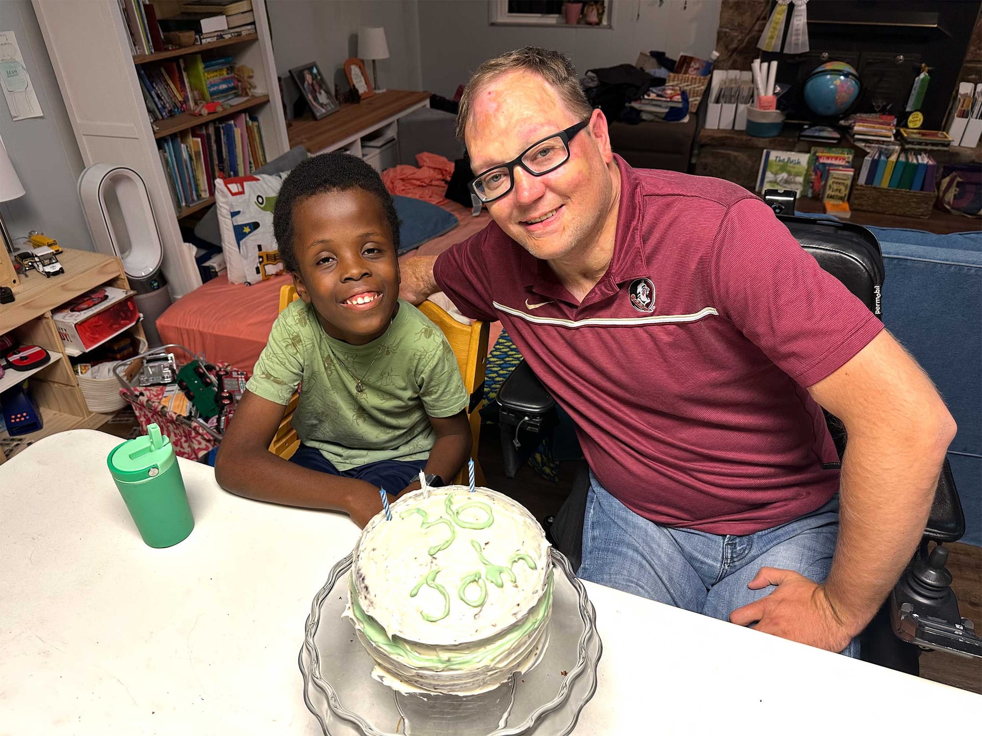 John and Robert posing with a birthday cake.