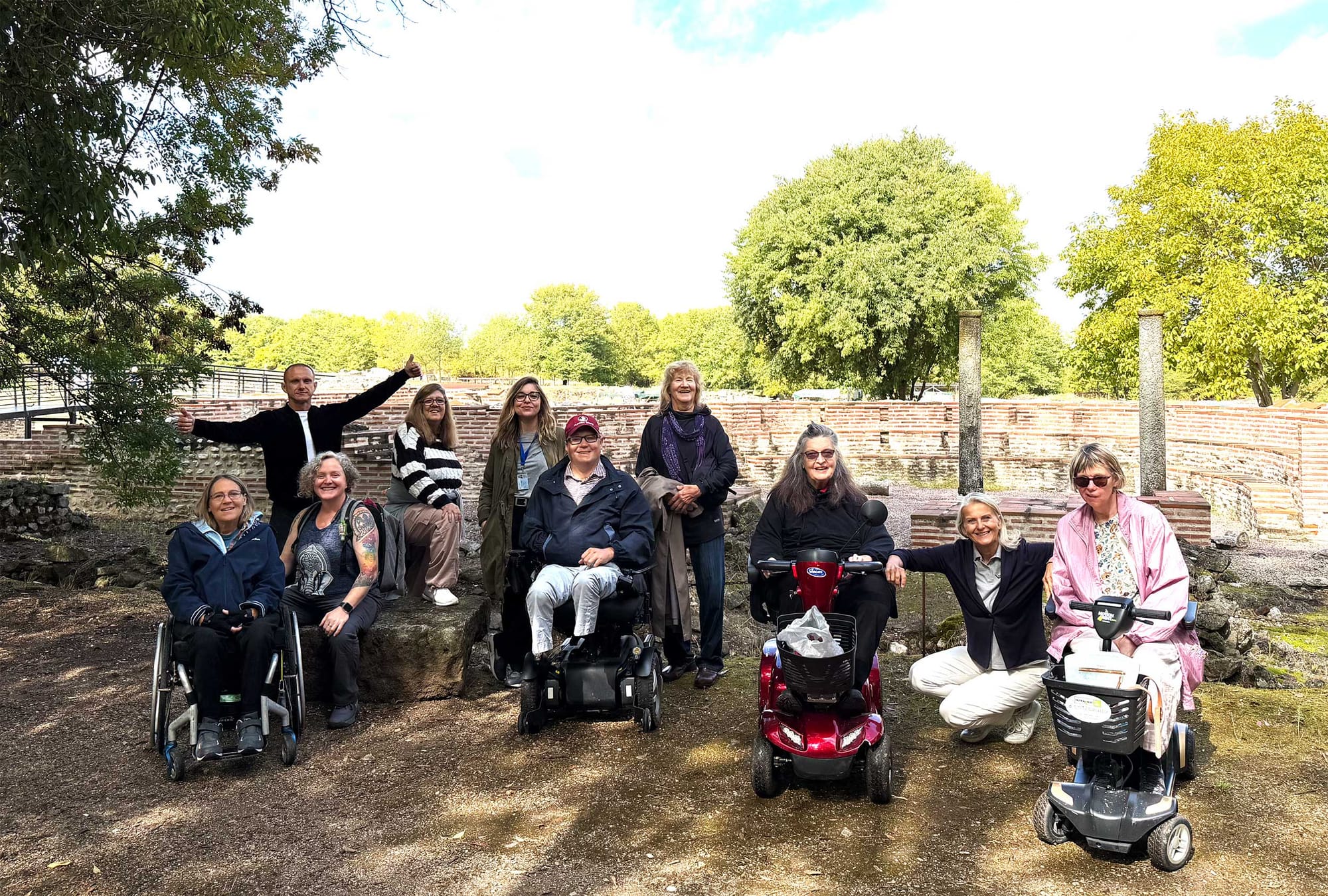 Group photos of wheelchair users in front of Greek and Roman ruins.