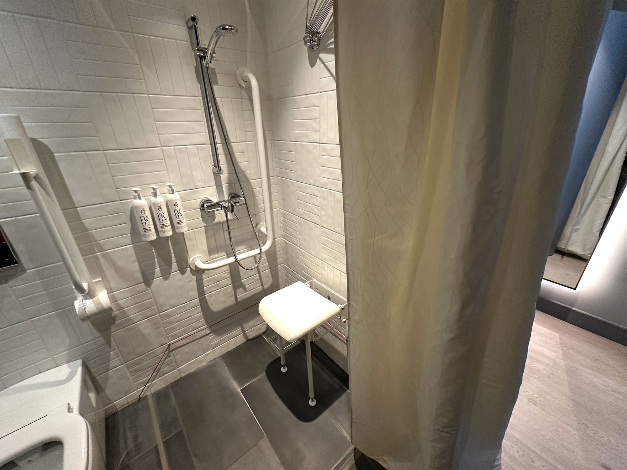 Roll-in shower with seat and grab bars.